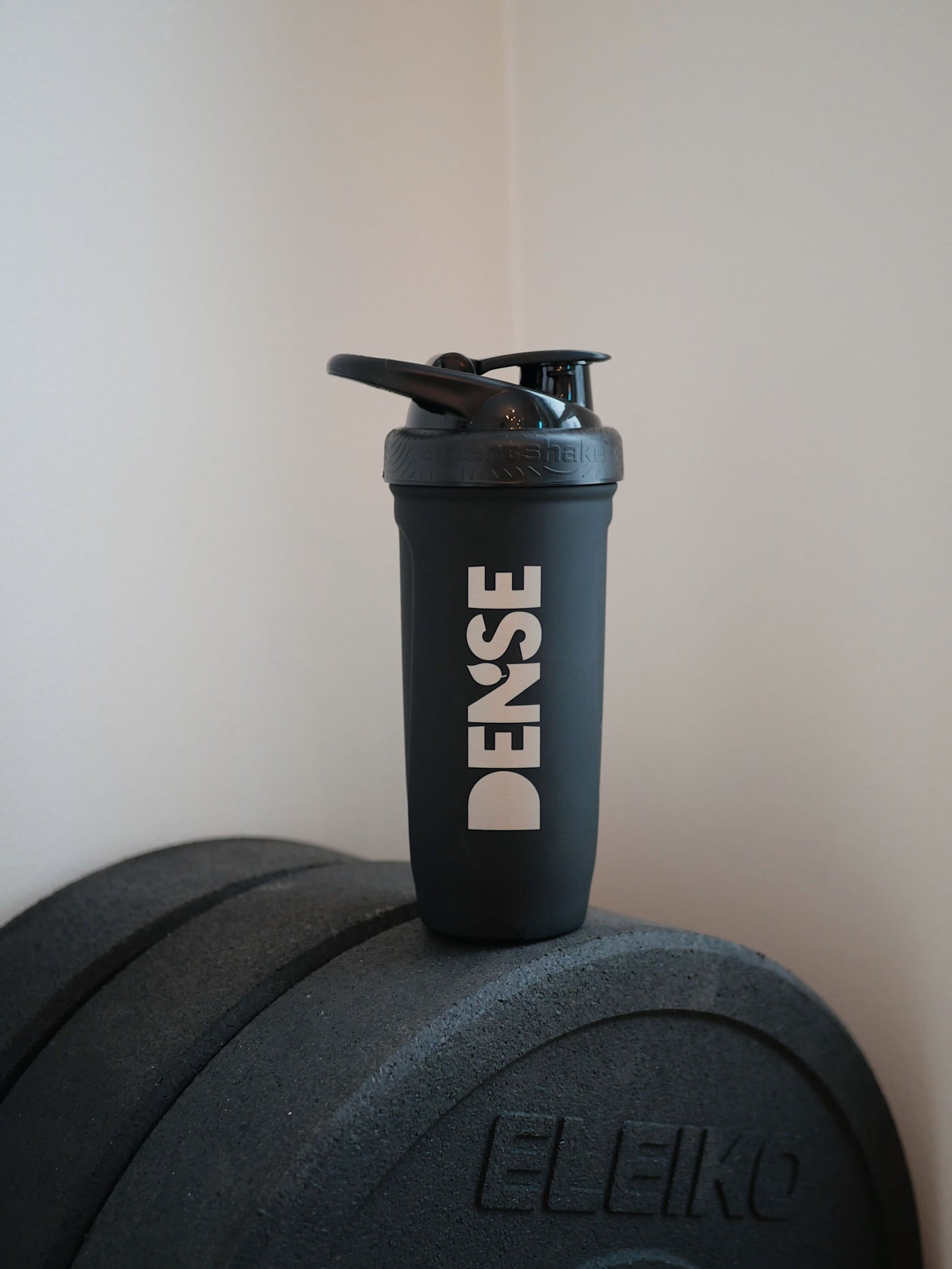 Smartshake Stainless Steel shaker bottle on weights, showcasing minimalistic design and sustainable material.
